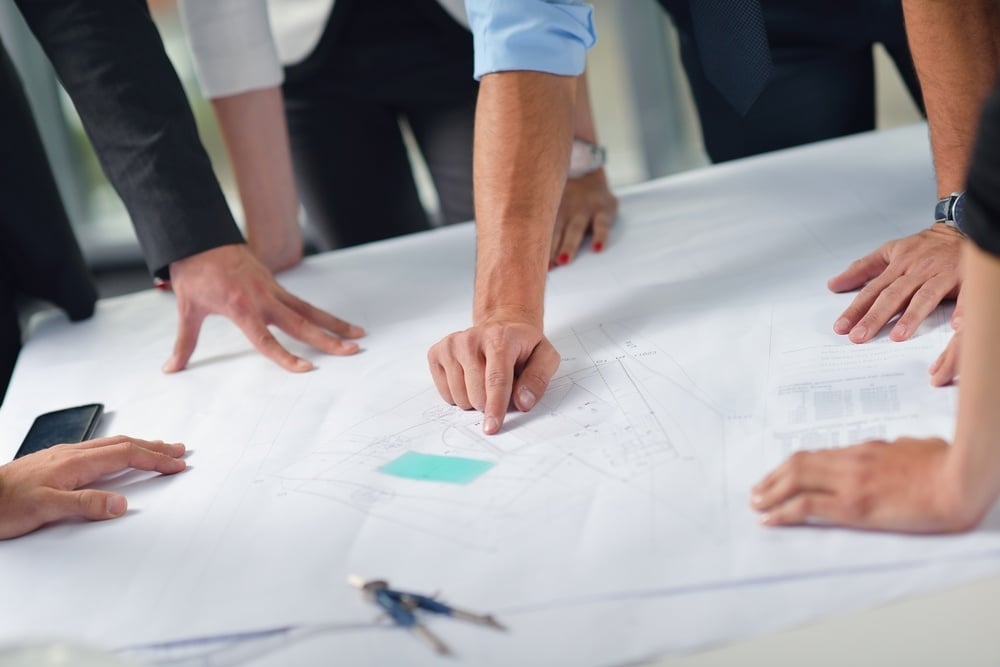business people group on meeting and presentation in bright modern office with construction engineer architect and worker looking building model and blueprint planbleprint plans